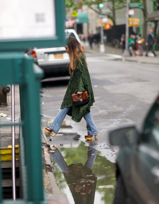 woman in poncho and flared jeans