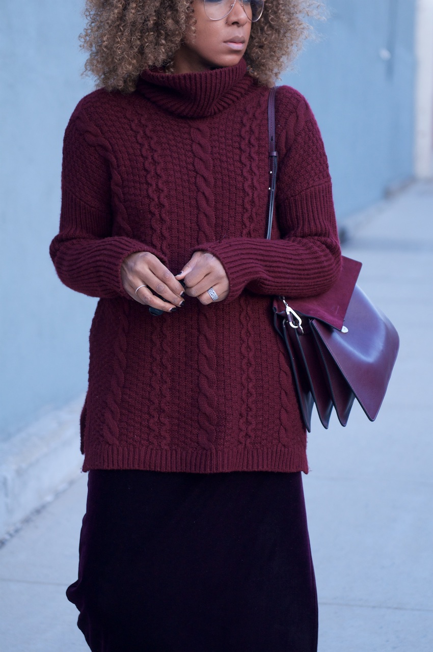 karen blanchard the fashion blogger with the Chloe faye bag in dark purple and cable knit sweater and clear aviator glasses