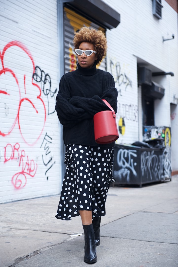 Karen Blanchard is wearing a red topshop bucket bag with a polka dot midi skirt