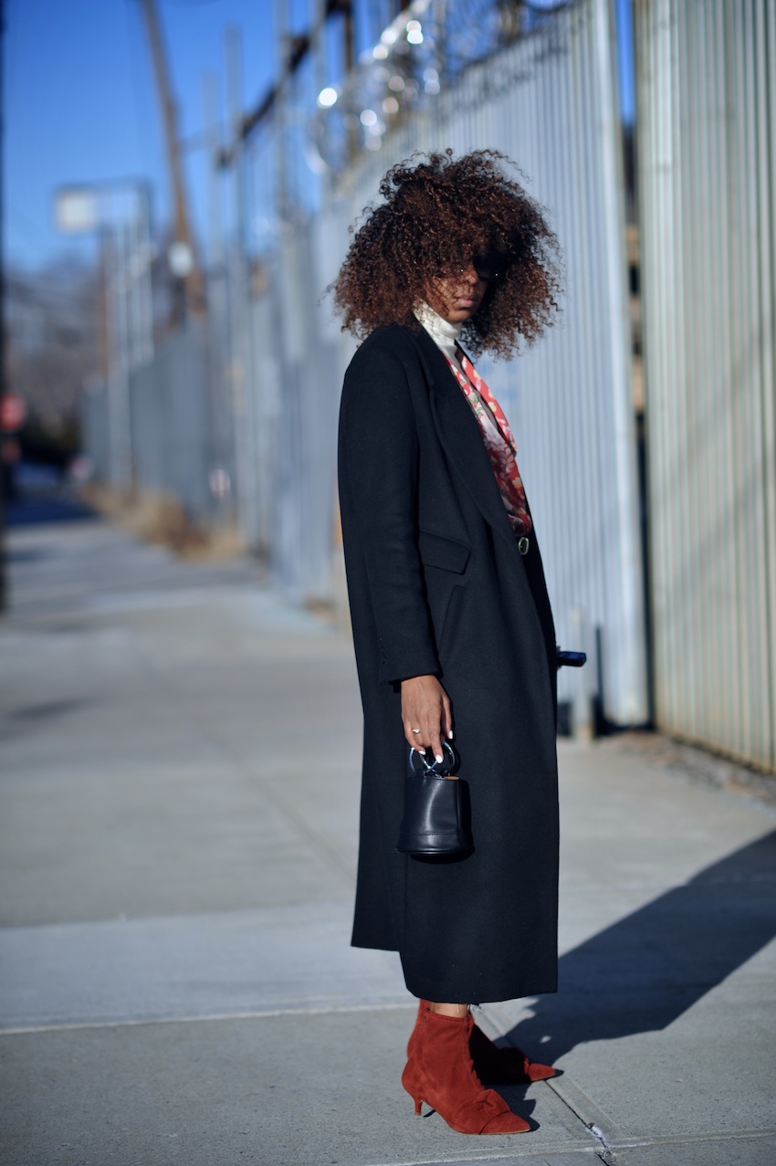 Karen Blanchard wearing a black H&M coat with zara red suede bow ankle boots and cropped levi jeans