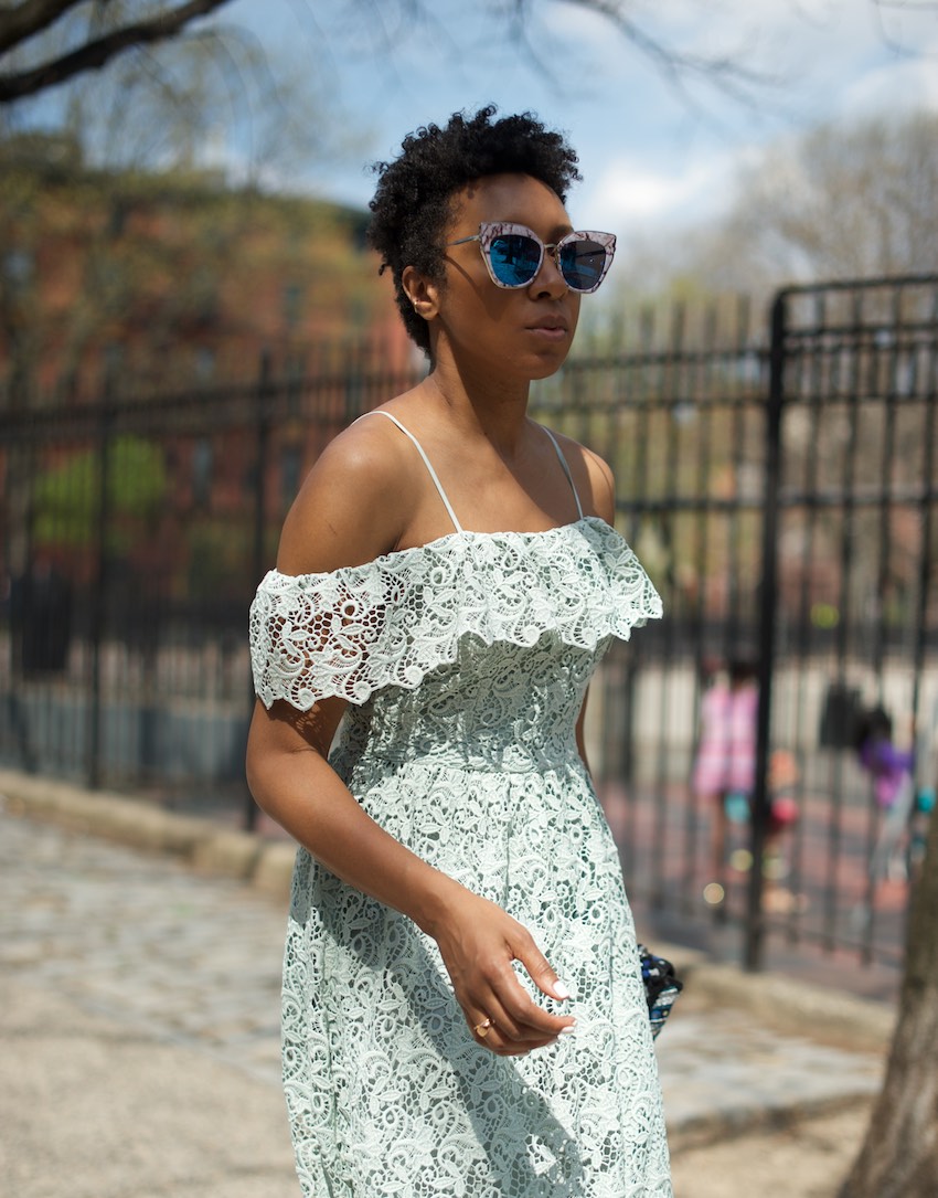 Karen blanchard with natural hair wearing statement sunglasses and an H&M lace dress